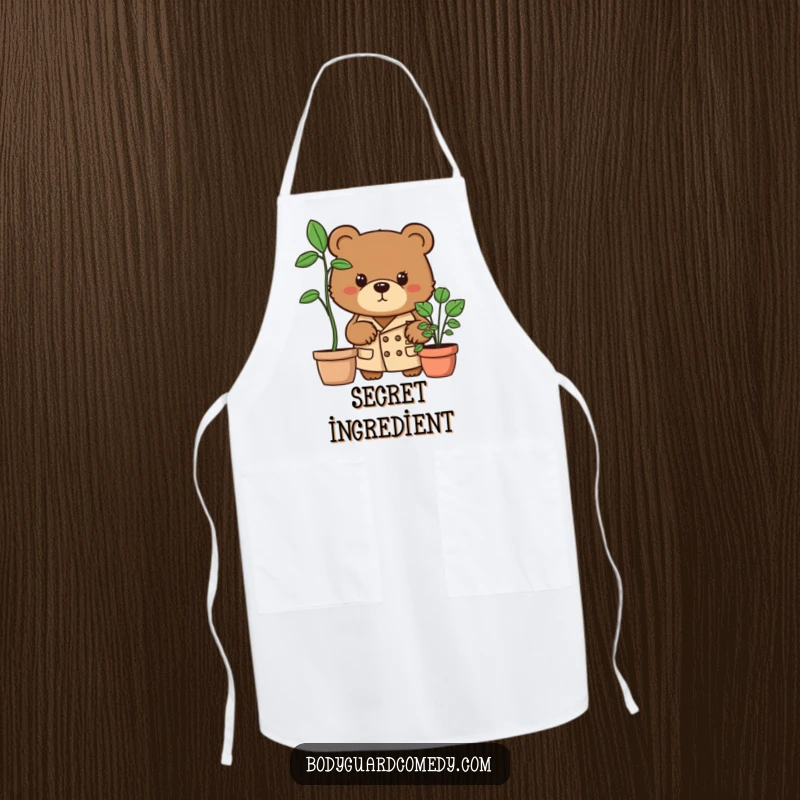 Funny brown bear in trench coat peering intently from behind a potted plant on an apron, great for cooking with a humorous spy theme.