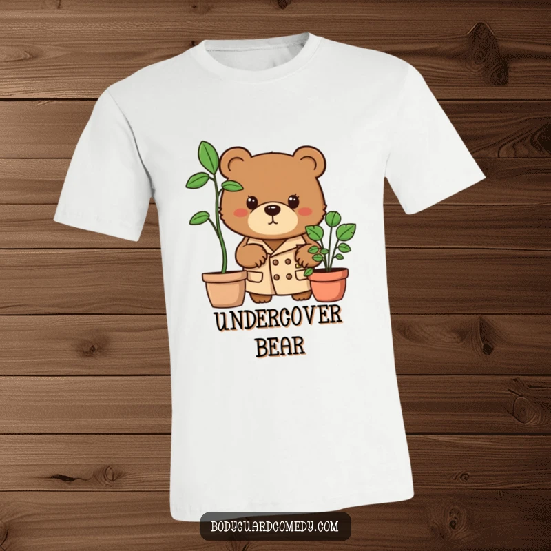 Funny brown bear in trench coat peering intensely from behind a potted plant on a t-shirt, showcasing a humorous spy-like persona.